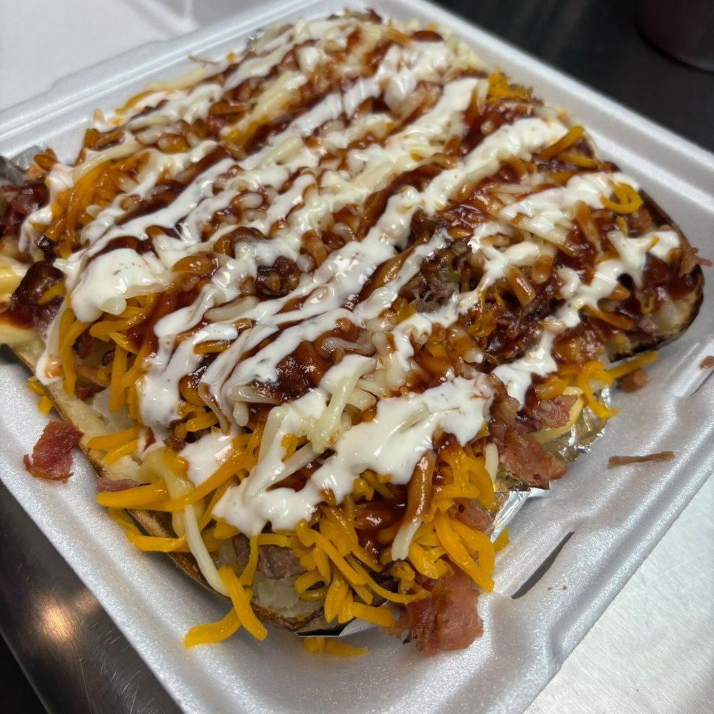 A BBQ potato boxed to go, with cheddar, barbecue sauce and ranch