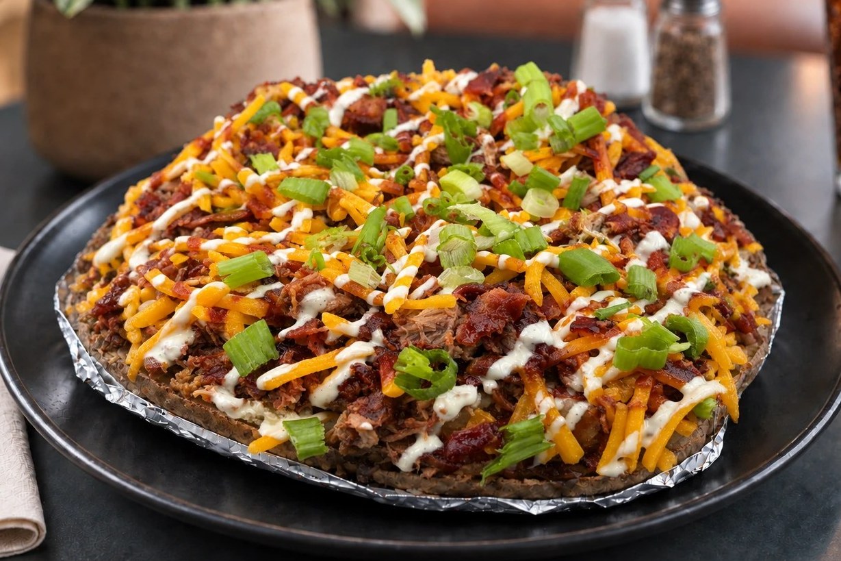 A jumbo baked potato piled with pulled pork, bacon, cheddar, ranch and green onions